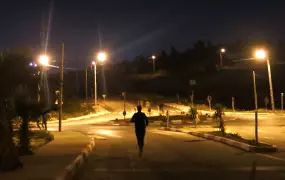 A woman runs late at night near Ramallah in the Occupied Palestinian Territory