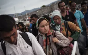 Refugees and migrants line up to board a night ferry from the Greek island of Kos to Athens