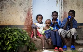 A group of children sit on the step of their families temporary home in Epworth, in Harare, Zimbabwe.