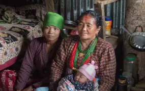 Bimala Thami sits with community health worker  Gauri Thami in October 2015 in the temporary shelter she lives in with her infant in Nepal's Dolakha district after her house was destroyed by a earthquake on 25 April 2015