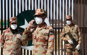 Paramilitary soldiers wear face masks as they stand in front of a closed gate at Pakistan's border post in Taftan. 