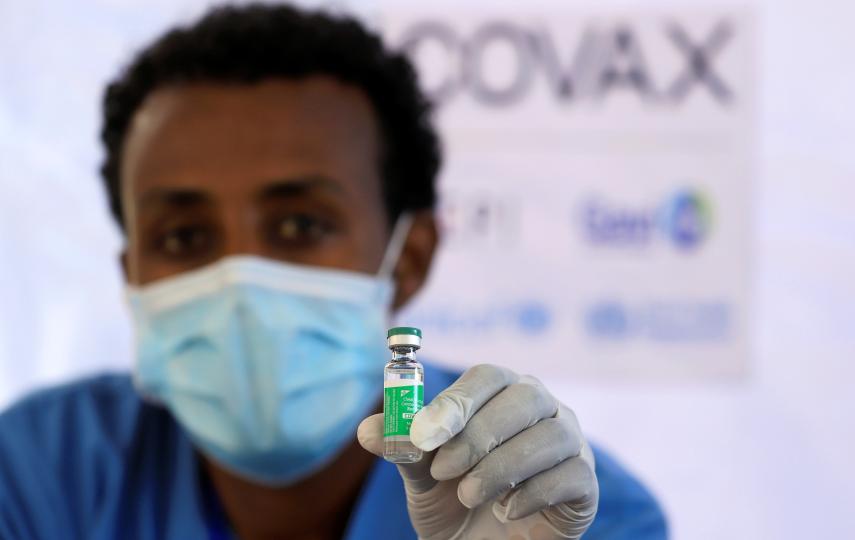 A nurse displays the AstraZeneca/Oxford vaccine.