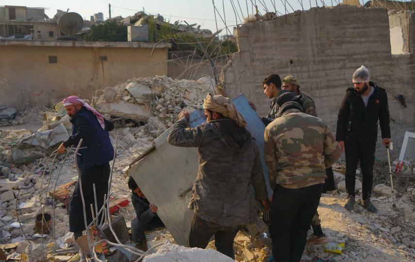 A group of men are cleaning up rubble that was created in the aftermath of the Syria-Türkiye quake in 2023.