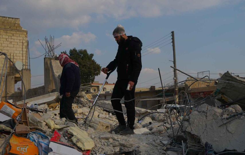 Men walk on top of rubble that was left in the aftermath of the Syrian earthquake. 