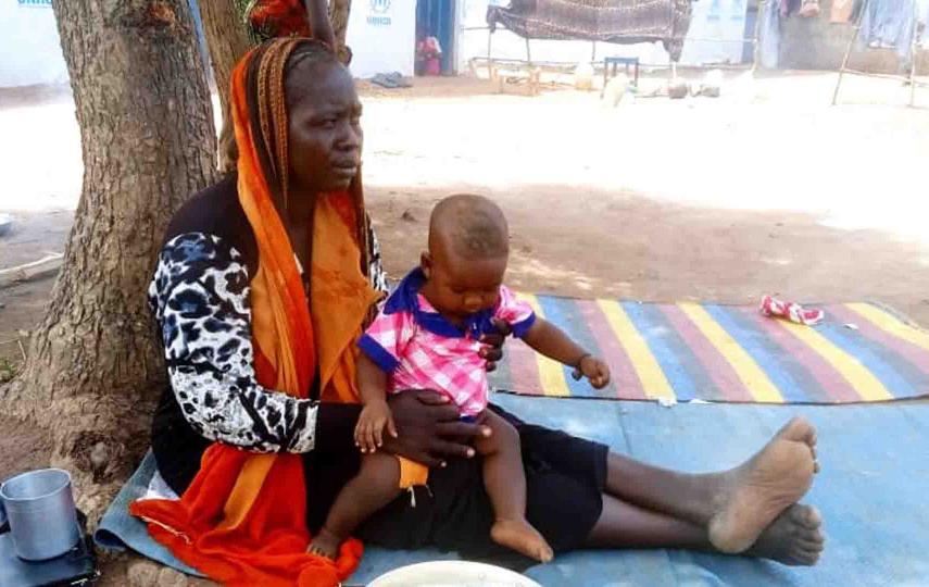 Abul Mathiang Ngong and one of her children take shade at Wedwiel refugee transit centre in South Sudan’s Northern Bahr el Ghazal state.