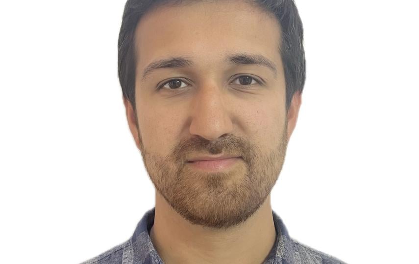This is a headshot of Mike Pearson. He looks at the camera with a slight smile. He wears a checkered shirt.