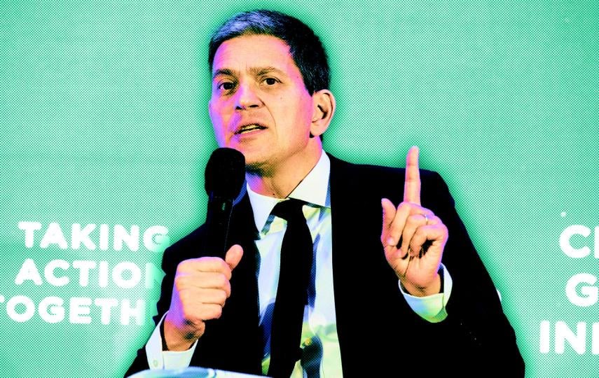 David Miliband, President and Chief Executive Officer, International Rescue Committee, is photographed mid-speech at the Clinton Global Initiative conference at the Hilton Midtown hotel in New York City. He holds a microphone in his right hand. With his left hand he his pointing upwards with his pointer finger.