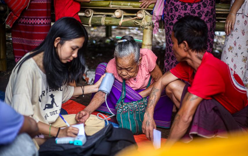 A volunteer checks the blood pressure of an elderly woman along the Myanmar/Thailand border.
