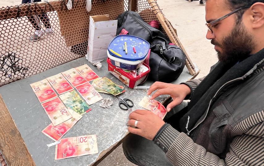 Ahmed al-Jayeh, 29, fixing worn-out bills at a stall he set up in Deir al-Balah's market.