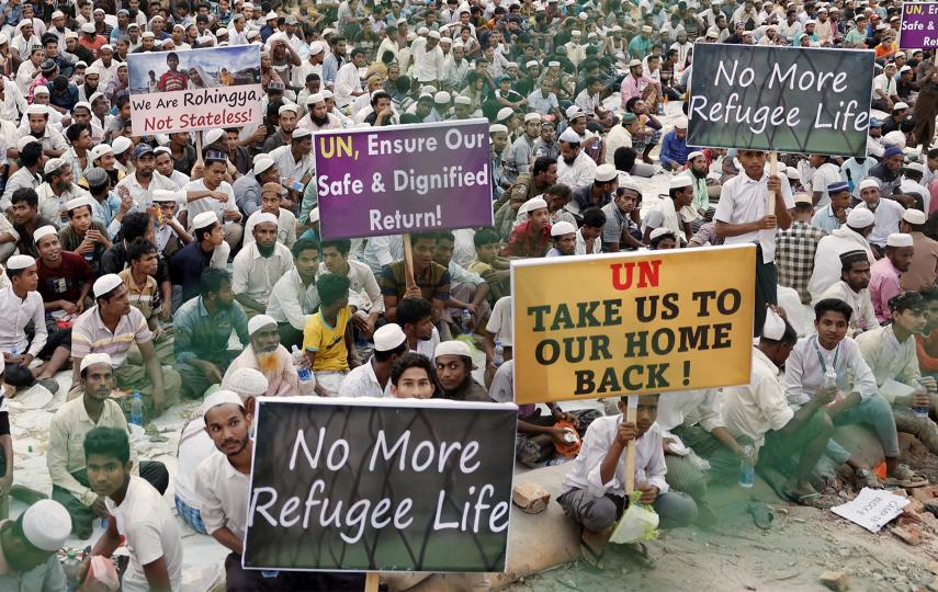Rohingya refugees hold placards while attending a Ramadan Solidarity Iftar to have an Iftar meal with United Nations Secretary-General Antonio Guterres and Muhammad Yunus, Chief Adviser of Bangladesh Interim Government, at the Rohingya refugee camp in Cox's Bazar, Bangladesh, March 14, 2025.