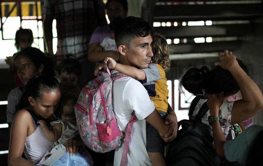 A man carries a child while waiting to register as a displaced person after being driven from his home by clashes between armed groups in Cucuta, Colombia earlier this year.