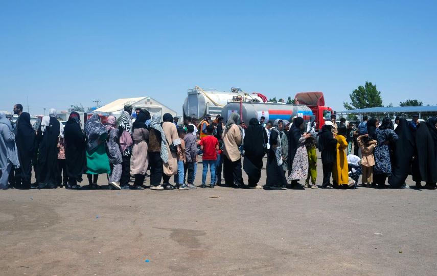 People from Afghanistan are pictured lining up in Islam Qala, a border town in the western Herat province of Afghanistan, near the Afghanistan–Iran border.