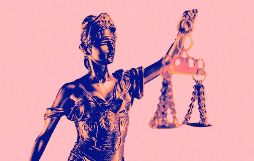 The image shows a statuette of Lady Justice. She is depicted wearing classical robes, with her eyes covered by a blindfold. She holds a balance scale suspended by chains. The image uses bold orange and blue tones against a light pink background. It has a graphic-art look.