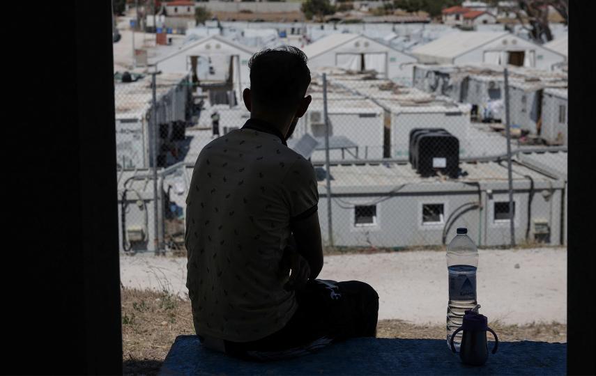 A refugee looking at a camp on the Greek island of Lesvos in June 2025