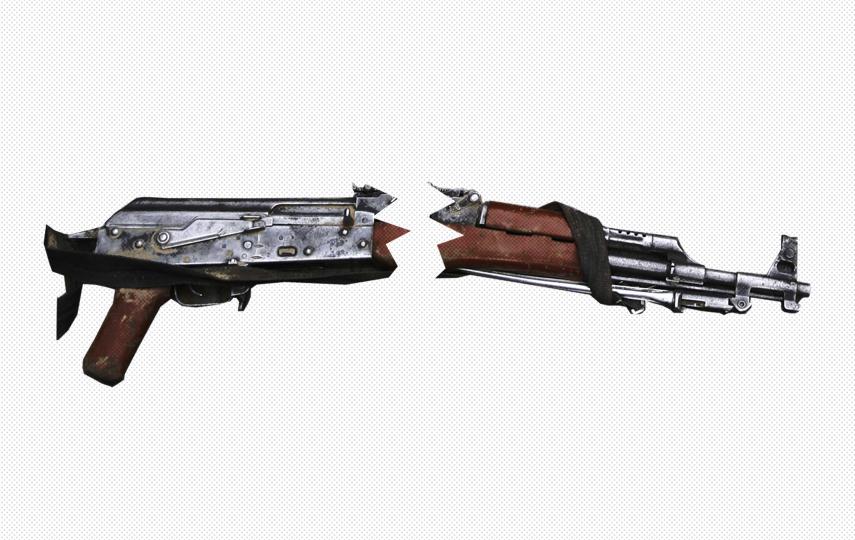 The image shows a broken assault rifle cut in half, with the two separated pieces slightly apart.