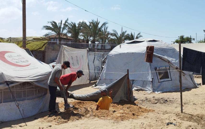Men working in the displacement camp in Nuseirat in the central Gaza Strip where Rasha and her family are living after being forced to move by Israel's assault on Gaza City.