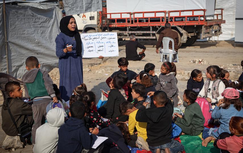 Displaced Palestinian children continue their education with the help of their teachers in a makeshift classroom in the Gaza Strip on 18 November 2025.