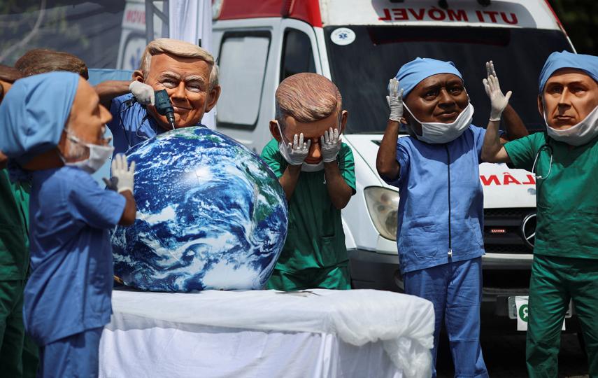 Oxfam activists wearing big head masks depicting world leaders stage a mock emergency room scene symbolizing a dying Planet Earth to call for urgent climate action during the UN Climate Change Conference (COP30), in Belem, Brazil, November 20, 2025.