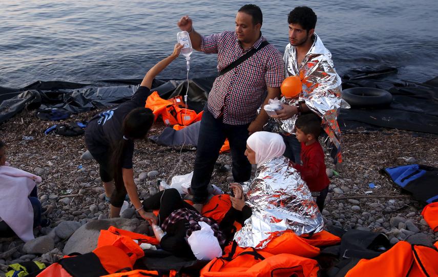Volunteers provide medical help to a pregnant Syrian refugee woman shortly after she arrived by boat with her family on the Greek island of Lesvos in September 2015.