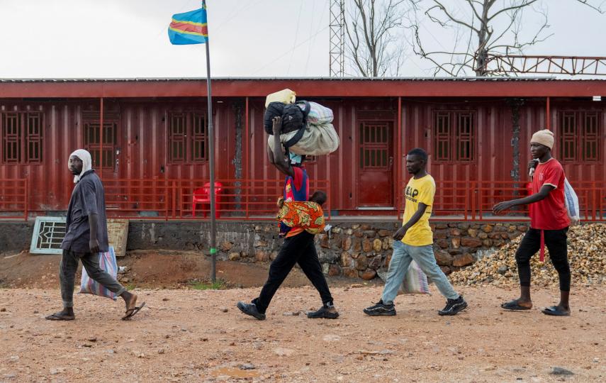 Foreigners who had been stranded during clashes between members of the Alliance Fleuve Congo AFC-M23 Movement who took over Uvira town from the Armed Forces of the Democratic Republic of the Congo (FARDC), walk to cross the border point in Uvira, on the shores of Lake Tanganyika, in South Kivu province, in the Democratic Republic of Congo December 14, 2025.