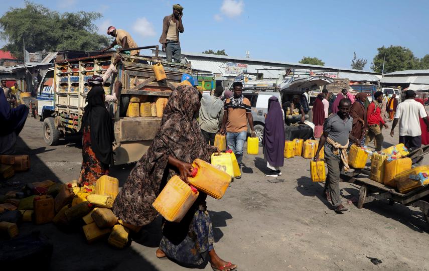 Somali traders gather to buy camel milk from zero-grazing units that confine animals and rely on purchased feed as traditional camel herders in Somalia revolutionize their ancient practices to survive devastating droughts and floods driven by climate change, at a dairy market in Hodan district of Mogadishu, Somalia October 31, 2025.