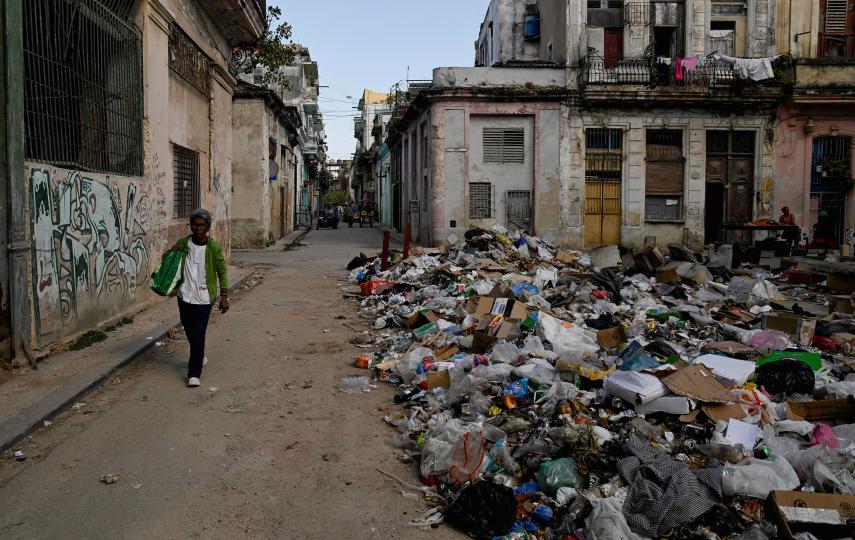 A woman walks next to trash on a street in downtown Havana, Cuba, February 15, 2026.