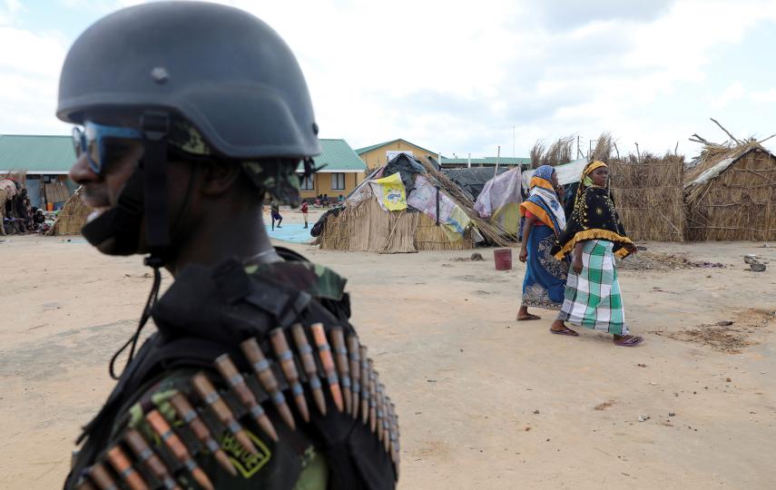 Women walk past a Mozambique soldier inside a camp for the internally displaced in the town of Quitunda, Mozambique September 22, 2021. Picture taken September 22, 2021.