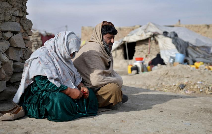 Samiullah, 55, and his wife Bibi Rehana, who along with their children were deported by neighbouring Iran, sit outside their tent on the outskirts of Kabul, Afghanistan, December 23, 2025.