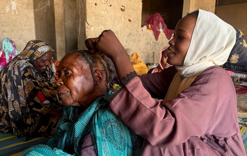 A displaced woman from Dalanj braids her grandmother's hair at a displacement registration center in El Obeid, North Kordofan State, Sudan, January 15, 2026.
