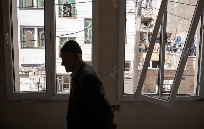 An elderly Afghan man stands in his apartment damaged in an airstrike on a residential building during military operations involving the United States and Israel, in Tehran, Iran, on March 27, 2026.