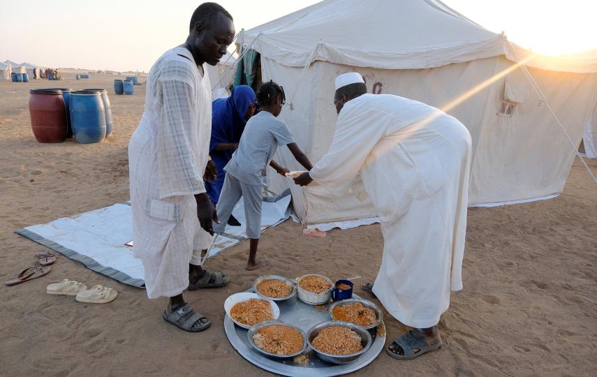 Volunteers deliver a meal of beans to a family at a displacement camp in Al-Dabbah, Sudan, on 12 November 2025.