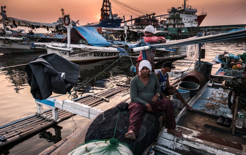 Fishermen on board a bangka, a traditional fishing boat inside the Navotas Fisheries Port Complex in Metro Manila.
