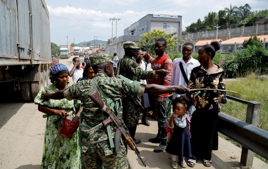 A member of the Ugandan military directing travelers at the Mpondwe border post after Uganda closed its borders with the Democratic Republic of Congo in an effort to contain the Ebola outbreak in the region.