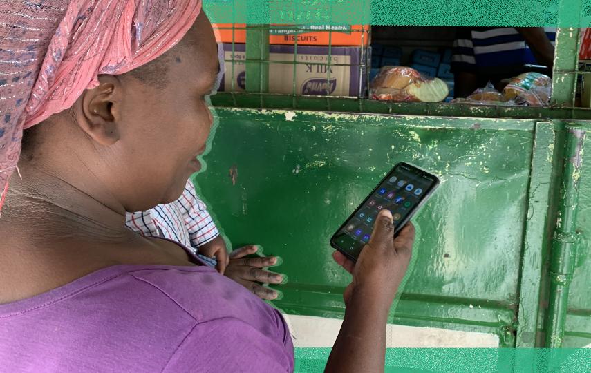 Kenyan housekeeper Brenda Vitute checks her mobile money wallet at an M-Pesa booth in Nairobi, Kenya on May 25, 2022. 