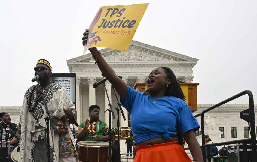 A woman holds a banner at a demonstration to call for continued Temporary Protective Status (TPS) of Haitians takes place as the Supreme Court hears oral arguments in Washington DC on 29 April, 2026.