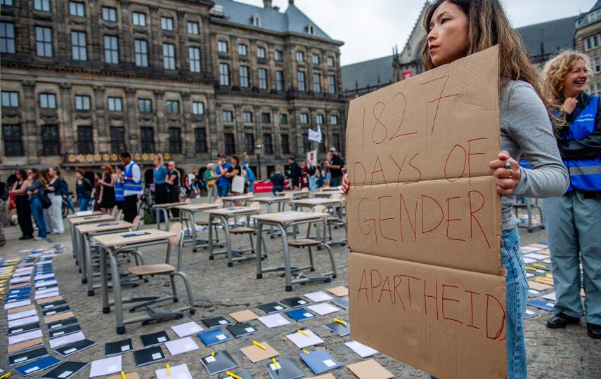 A woman holding a sign that reads 1827 days of gender apartheid at a a demonstration in Amsterdam, Netherlands at a protest for women and girls in Afghanistan.