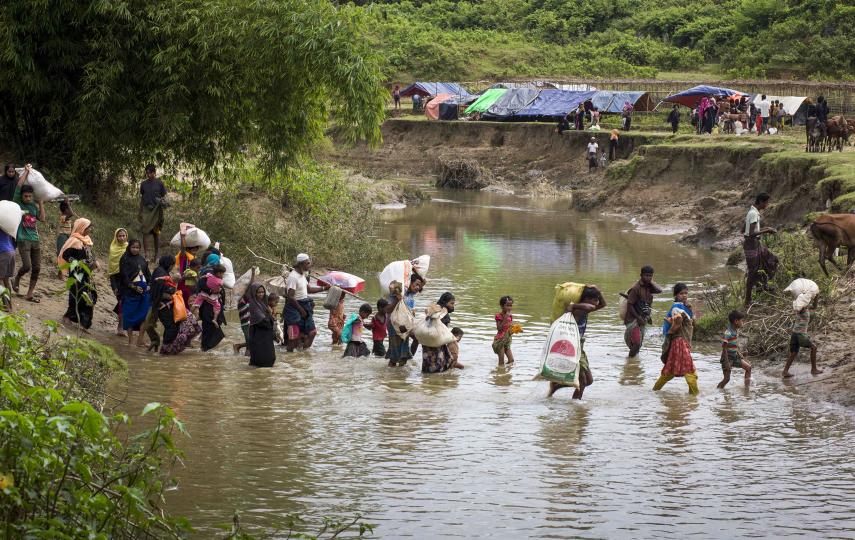A file photo dated 28 August 2017 shows Rohingya Muslims crossing a river, fleeing from ongoing military operations in Myanmar's Rakhine state, crossing Bangladesh Myanmar border as they try to arrive at Cittiagong, Bangladesh. 