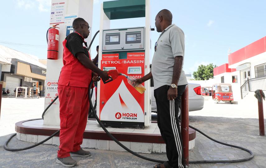 A fuel station attendant sells petrol in a bottle to a rickshaw driver in Mogadishu as prices soar in response to the Gulf crisis, 25 March, 2026.