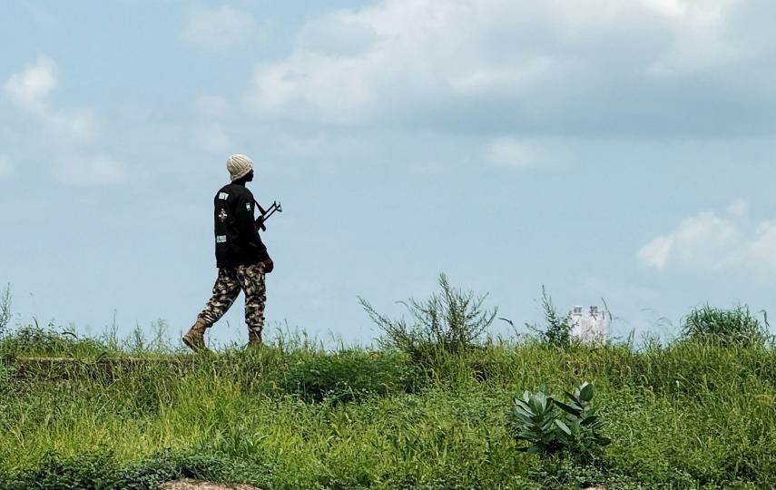 A Nigerian Army personnel walks along a field standing guard. This is for farmers who are returning from their fields after receiving security clearance in Dikwa town, Borno State, Nigeria, 27 August 2025.