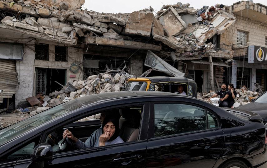 A displaced resident inside a car looks out at destruction caused by Israeli strikes as she drives home following a 10-day ceasefire between Lebanon and Israel that went into effect, in Nabatieh, Lebanon, 18 April 2026.