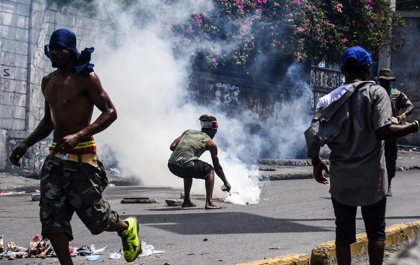 A demonstrator douses a tear gas canister with water during a protest in Port-au-Prince, Haiti, on 27 September 27, 2019.