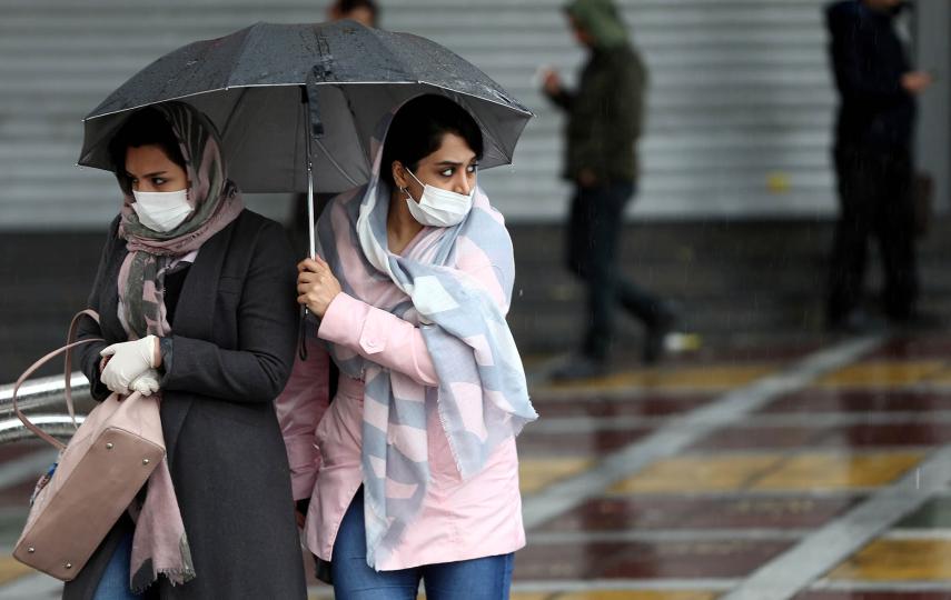 Iranian women wear protective masks to prevent contracting coronavirus as they walk in the street in Tehran.