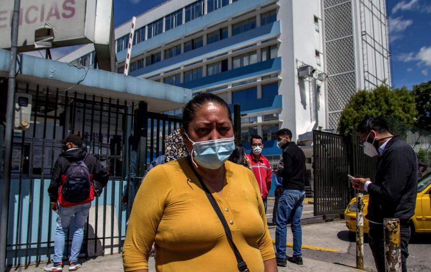 Isabel Juela visiting her husband at a public hospital in Quito. After months of delay, they were forced to go to a private clinic for his brain surgery. They now owe over $15,000.