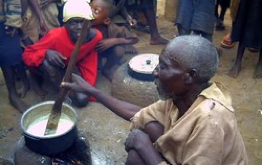 [Burundi] And old Burundian refugee man cooks maizemeal on a clay stove at the Nyakimonomono way station in Kibondo District, northwestern Tanzania. [Date picture taken: March 2006]