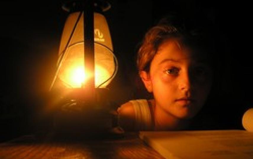 A girl in Beit Lahiya sits by a lantern during one of the daily power cuts in Gaza, 09 March 2006. Gazans receive on average between six and eight hours of electricity per day after the Israeli military bombed the city’s only power station on 28 June 20