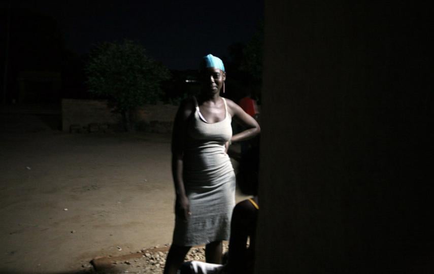A sex worker stands outside a bar, March 2007. Alcohol and drug use can lower inhibitions, increasing the risk of HIV infection. However, some groups are especially vulnerable - most notably young women. The impact of HIV/AIDS has gone far beyond the hous