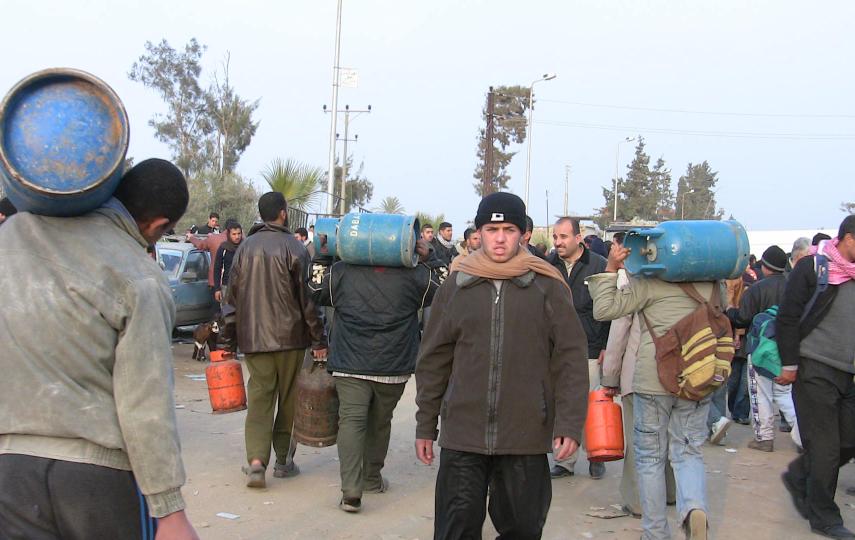 Young Palestinian men in Egypt carry gas cylinders back over the border to Gaza. Thousands of Gazans broke through the border to Egypt on 23 January for a massive shopping spree as their supplies were desperately low following an Israeli blockade. They sa