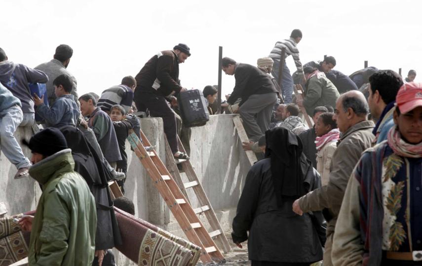  Palestinians cross  over a section of the border wall seperating the Gaza Strip from Egypt at Rafah crossing point January 2008.