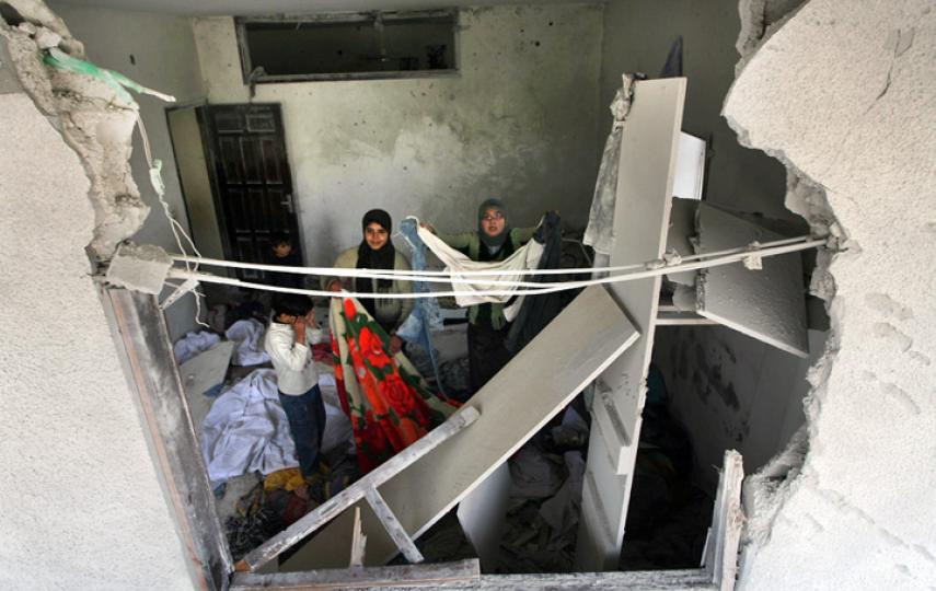 Palestinians stand inside their home in the Jabalya refugee camp 02 March 2008, damaged during an Israeli incursion and airstrikes which left about 115 Palestinians dead in Gaza over five days.
