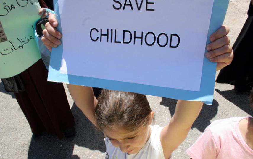 A young girl holds a banner during a recent rally in Amman to promote children rights in the kingdom.